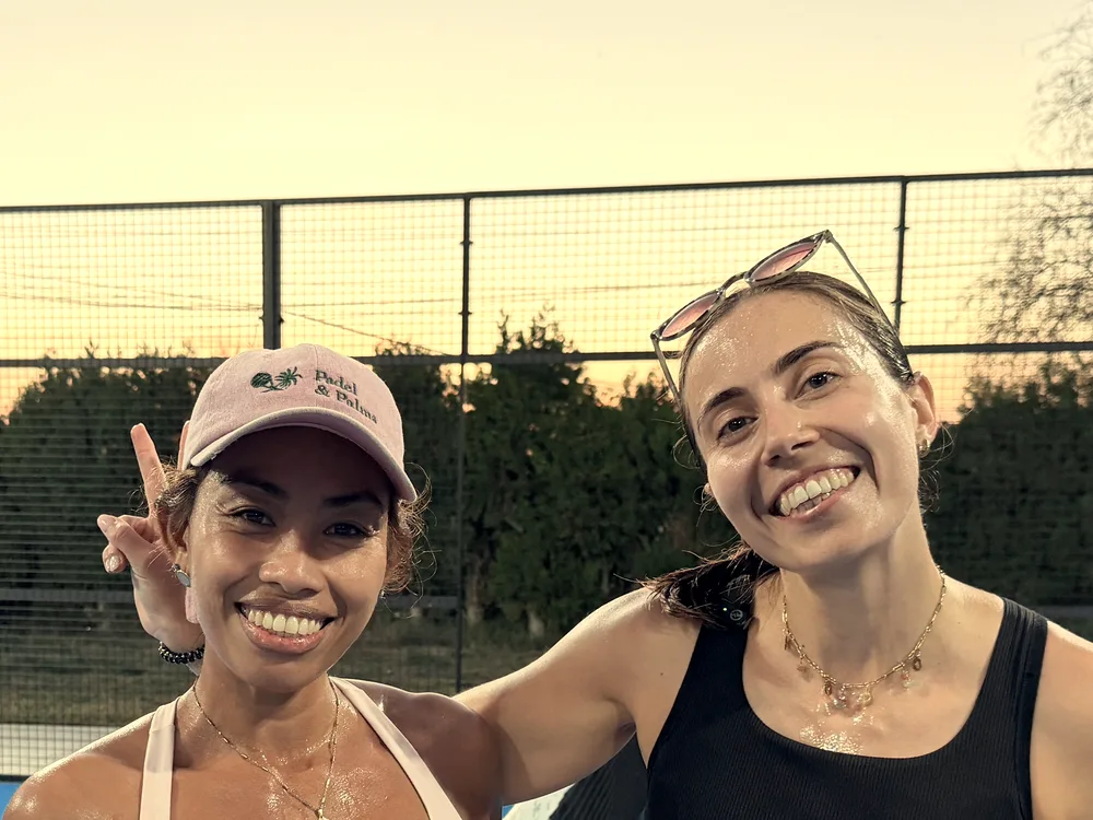 Two players laughing on court at sunset