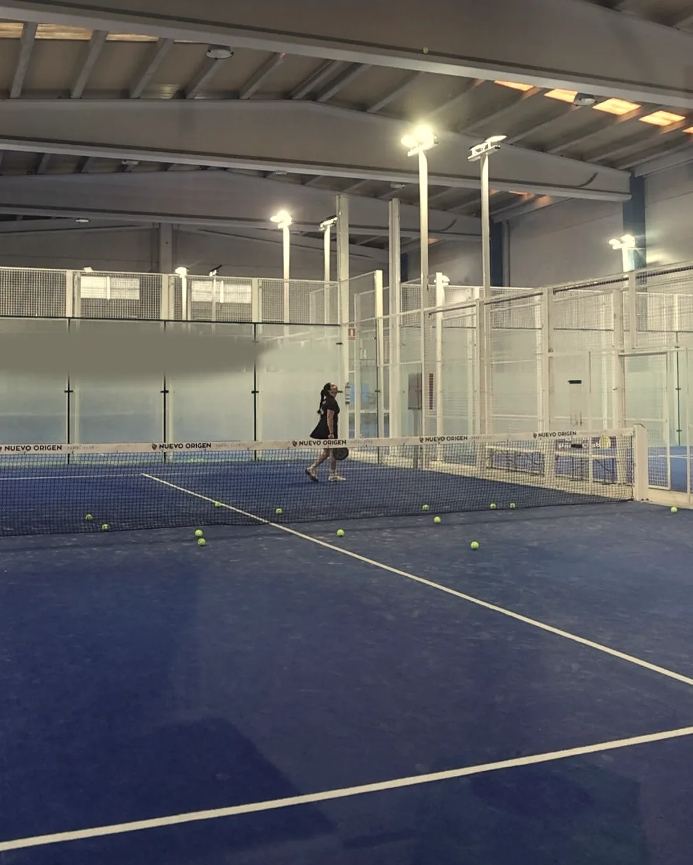 The covered hall at Origen Padel Club: the roof, the floodlights and a blue court with its net